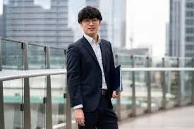 ビジネスウェアで書類フォルダを抱える様子のイメージ